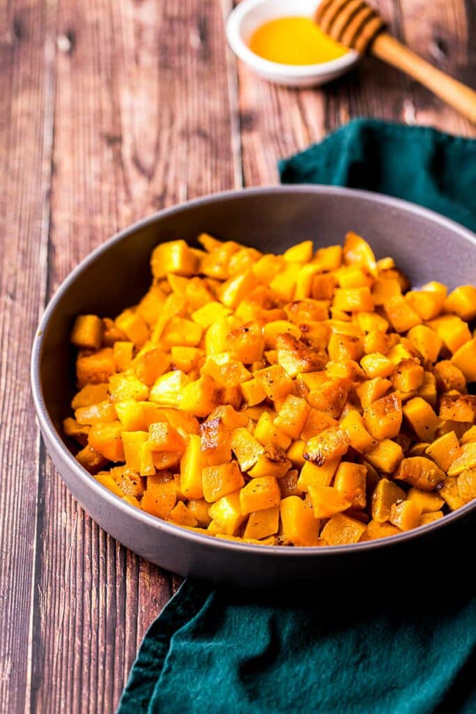a bowl of cooked butternut squash on a blue towel