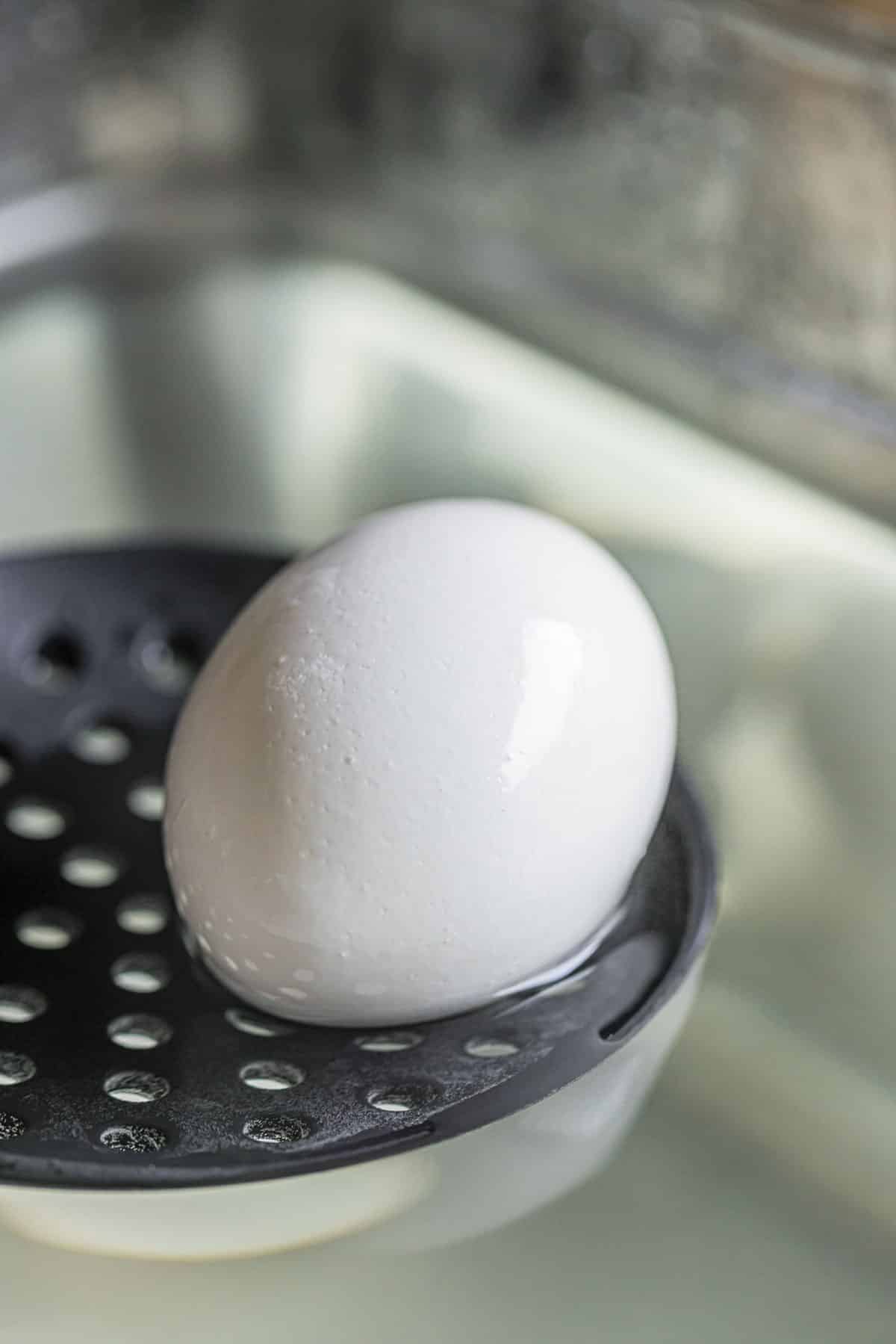 a boiled egg on a slotted spoon
