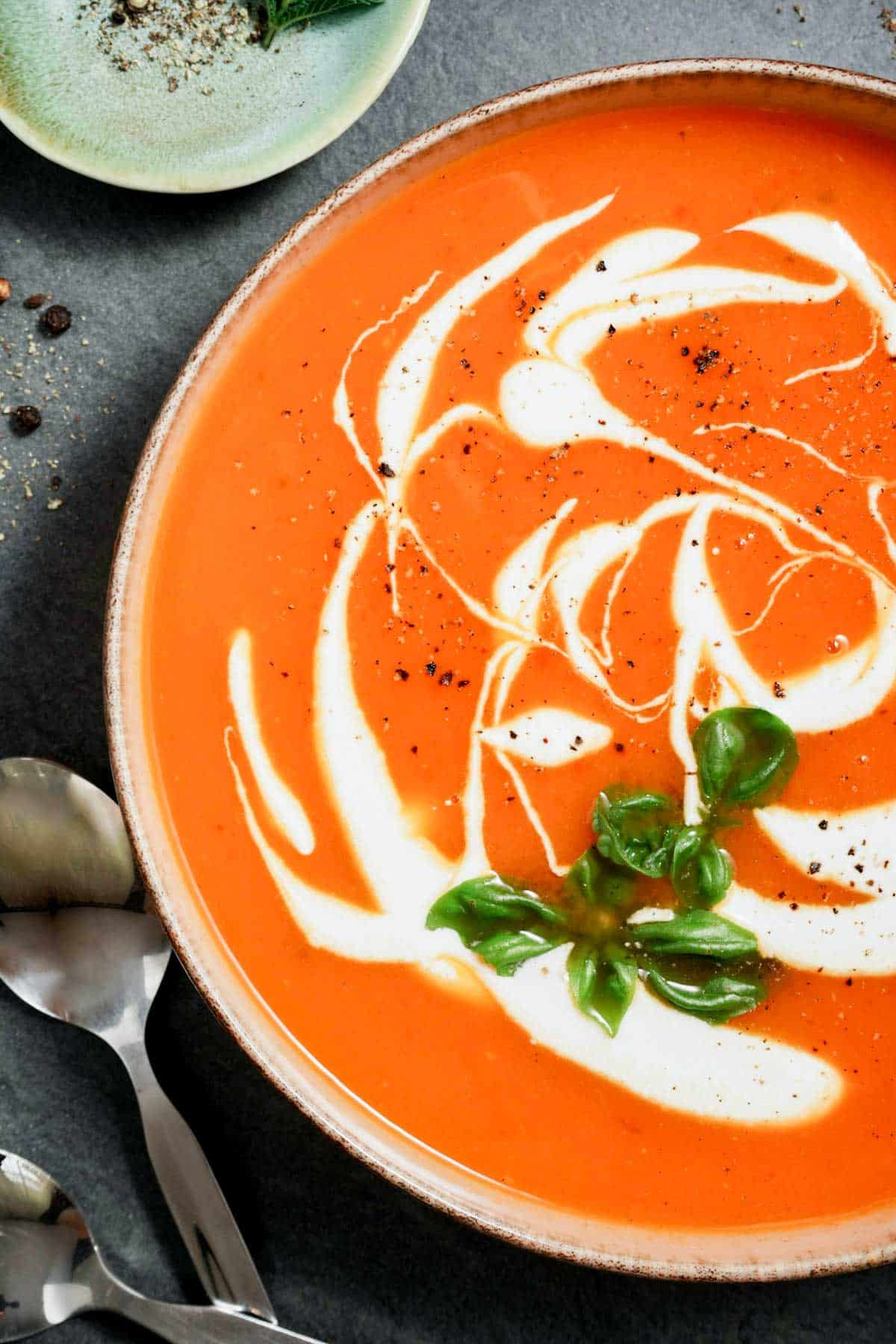 sweet potato soup swirled with cream and herbs in a bowl
