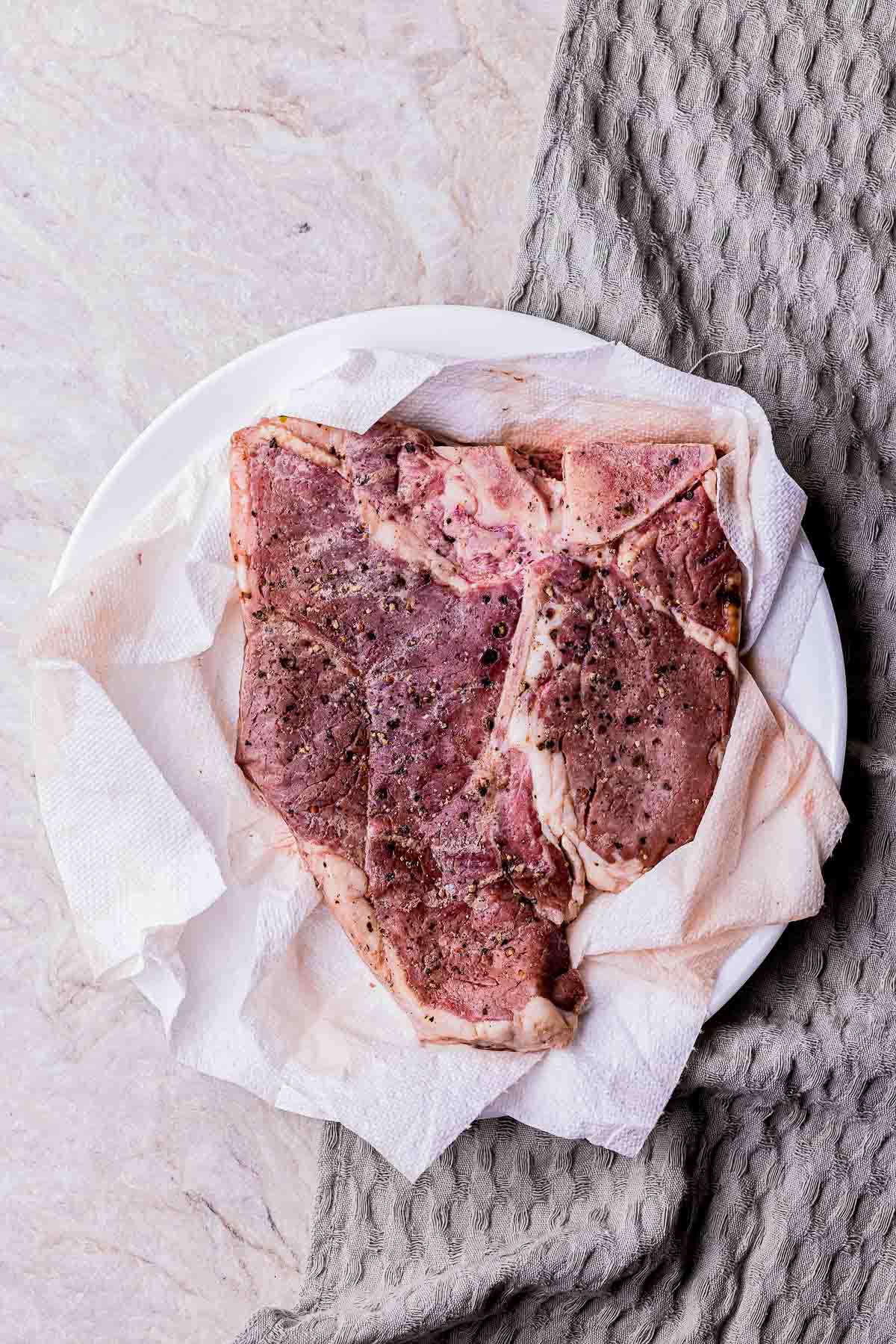 cooked porterhouse steak blotted with paper towels
