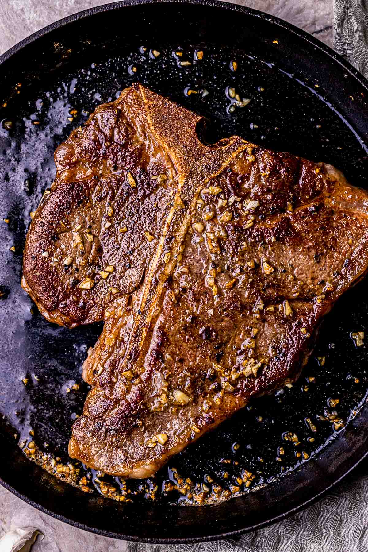 a steak browning in a skillet