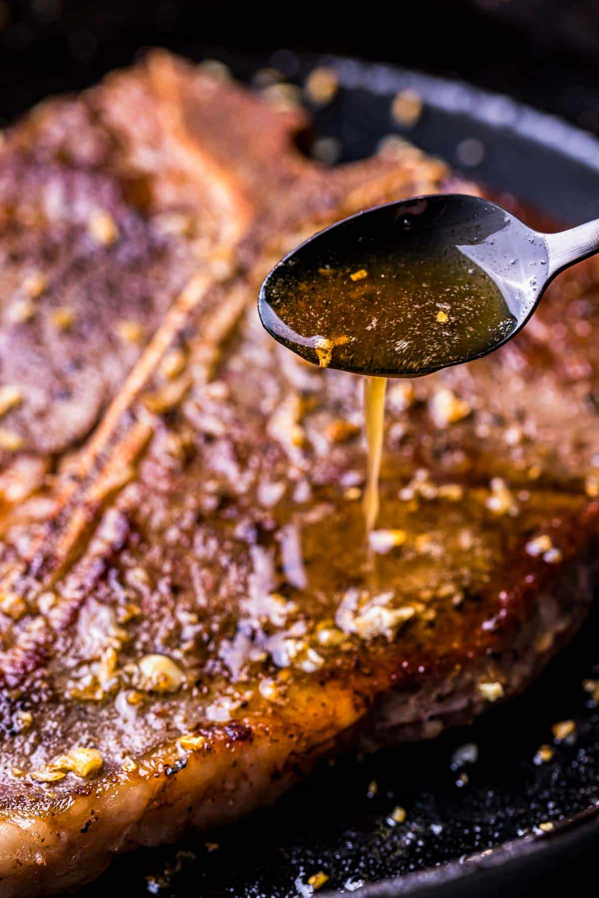 a steak being basted with butter in a skillet