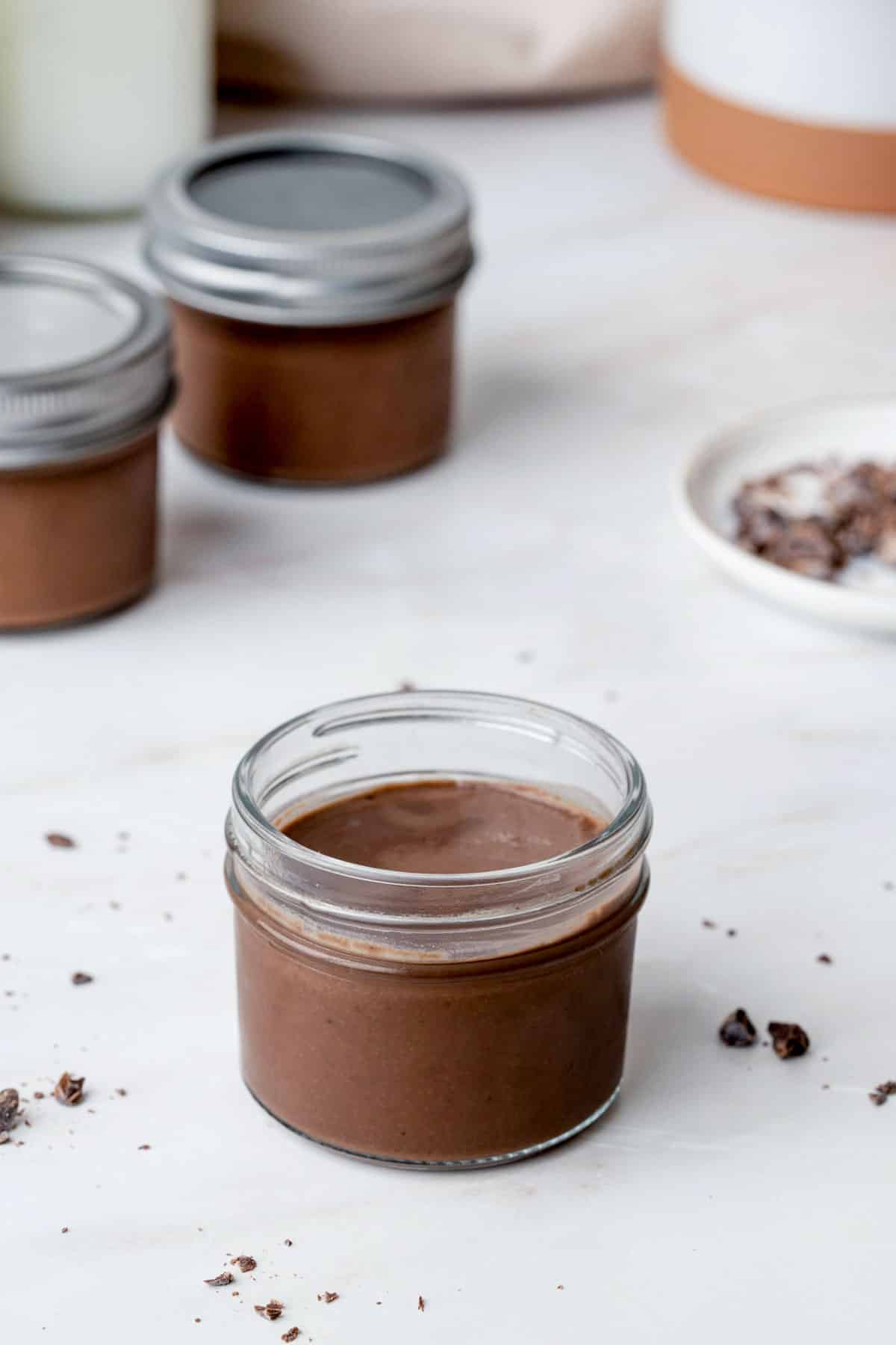 chocolate creme in a jar on a white table top