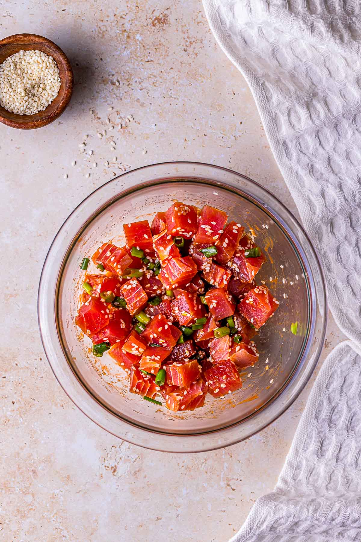 chopped raw tuna in a bowl with green onions and sesame seeds