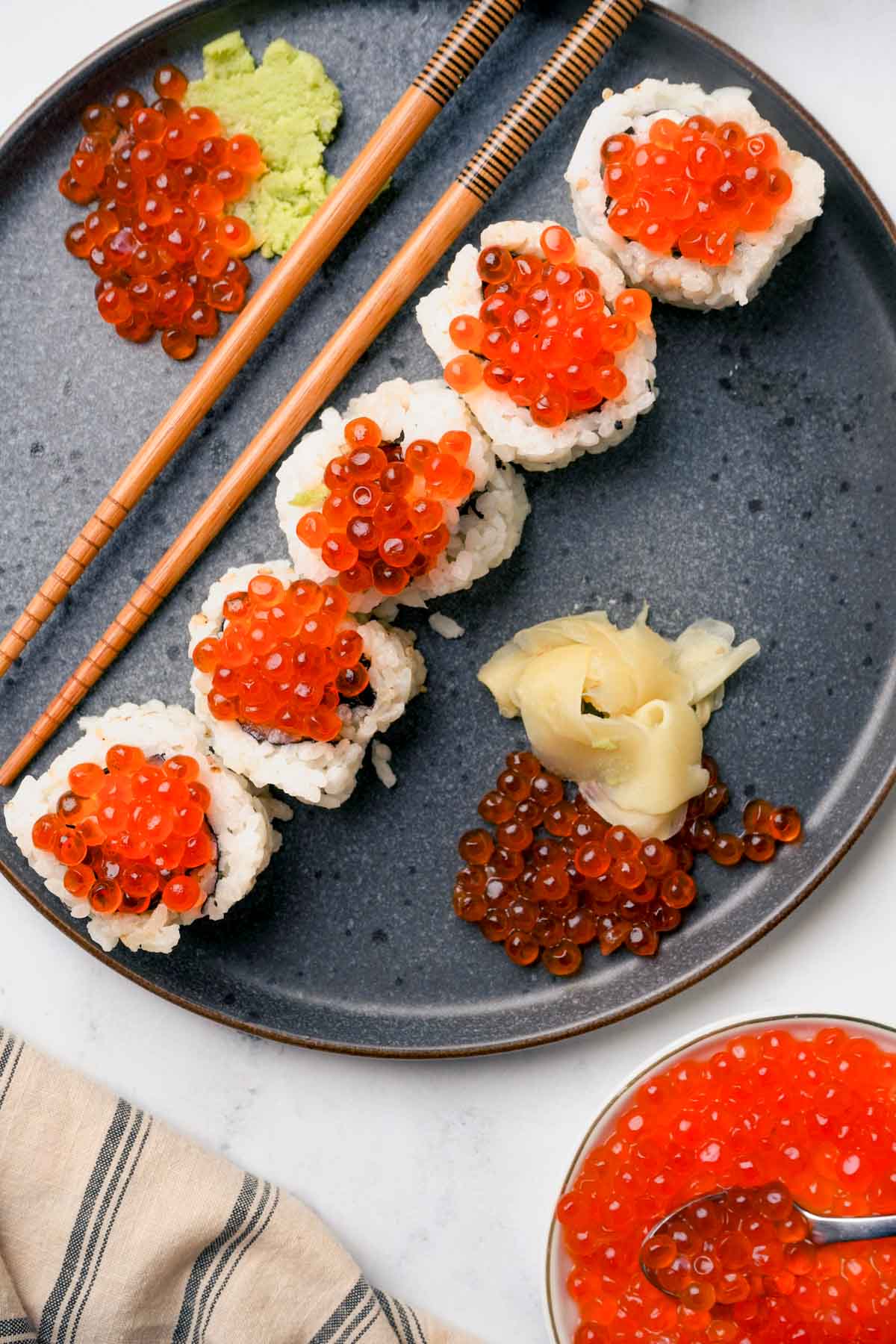 salmon roe on top of sushi rolls on a plate