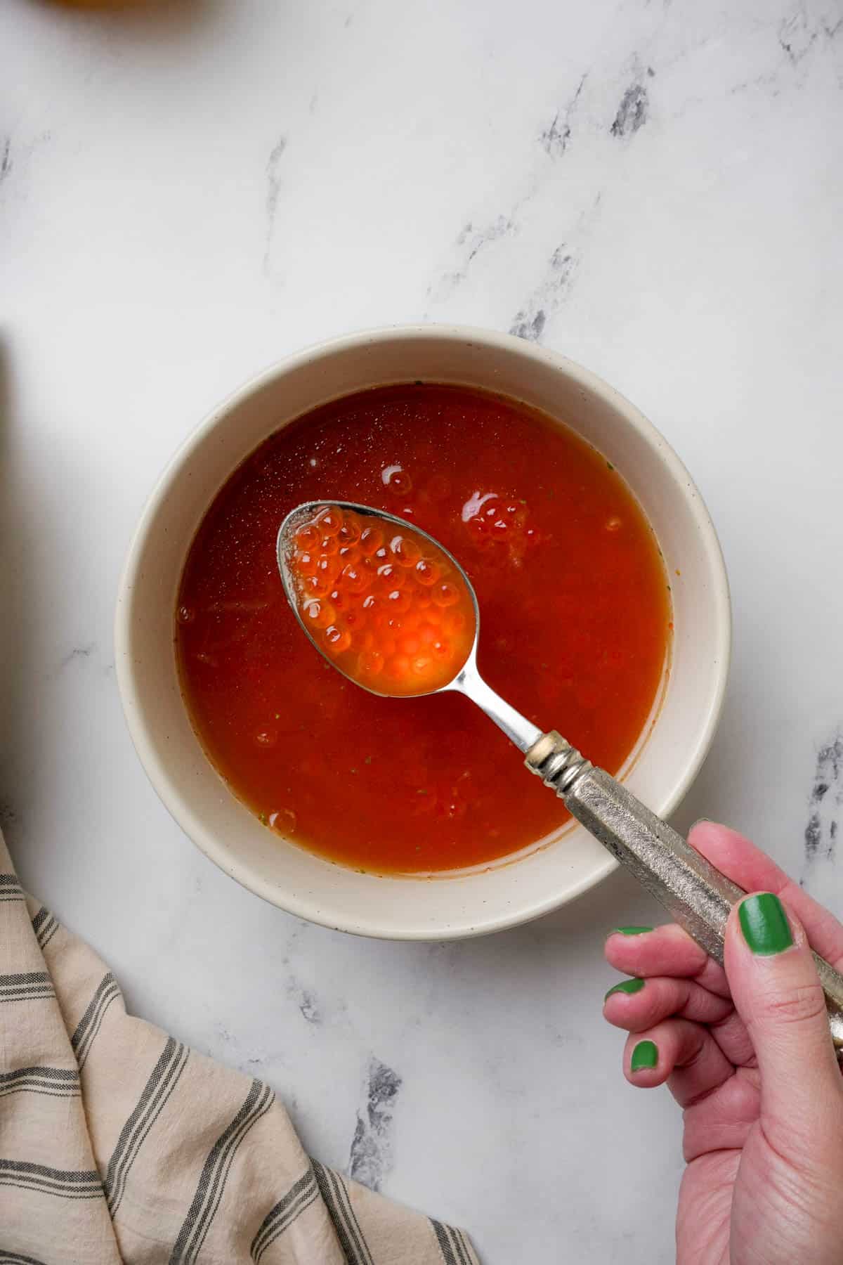 salmon roe being cured in a liquid in a bowl