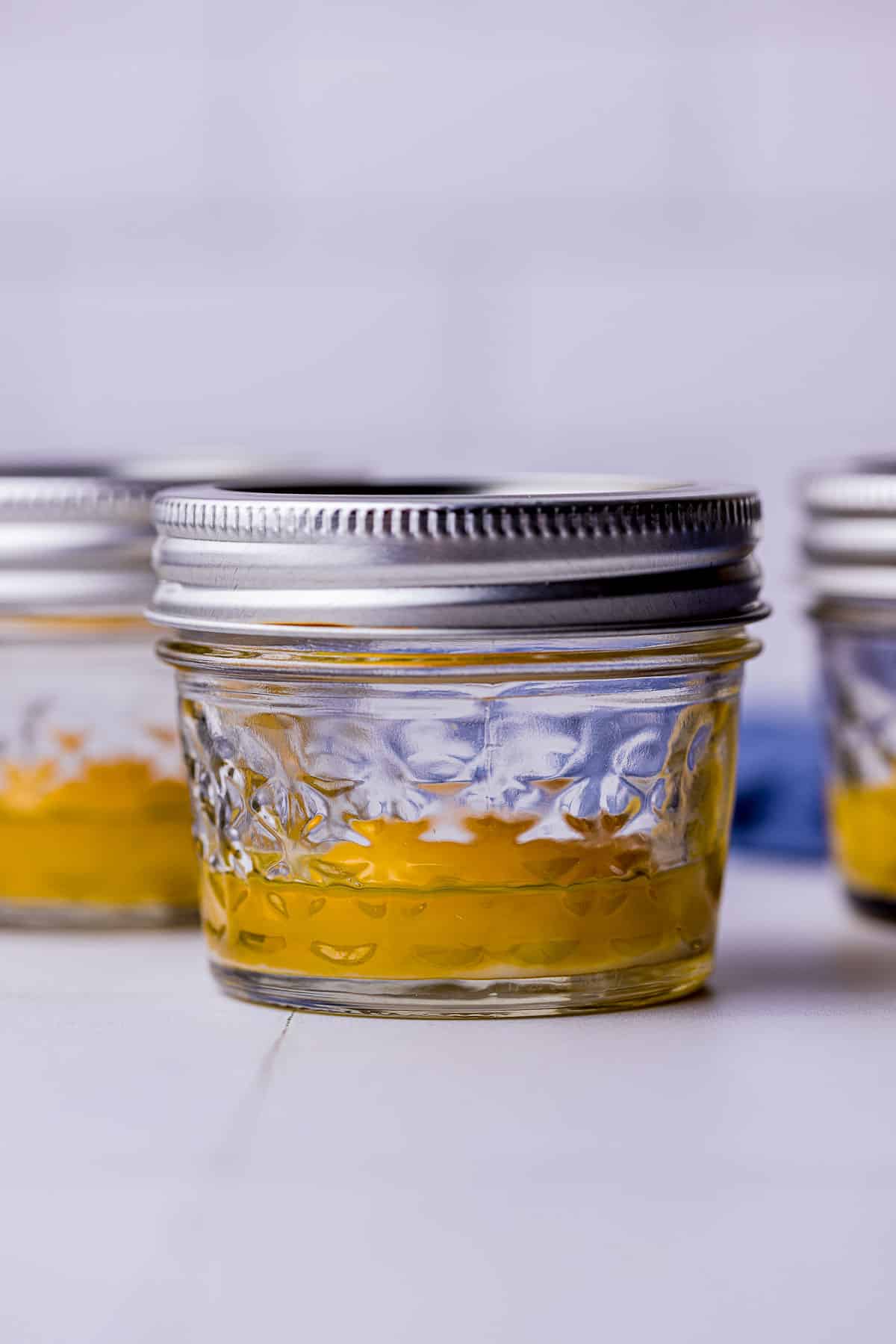 single egg yolks in jars with olive oil
