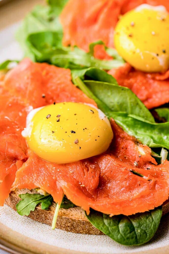 an egg yolk on cured salmon toast