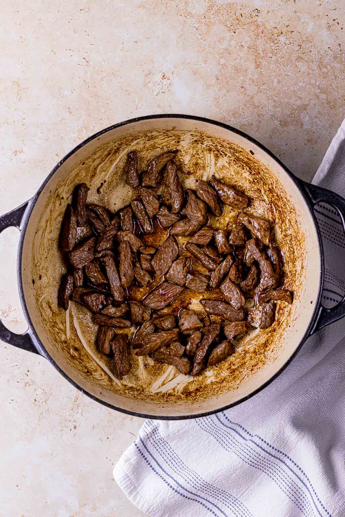 browned pieces of beef in a pot