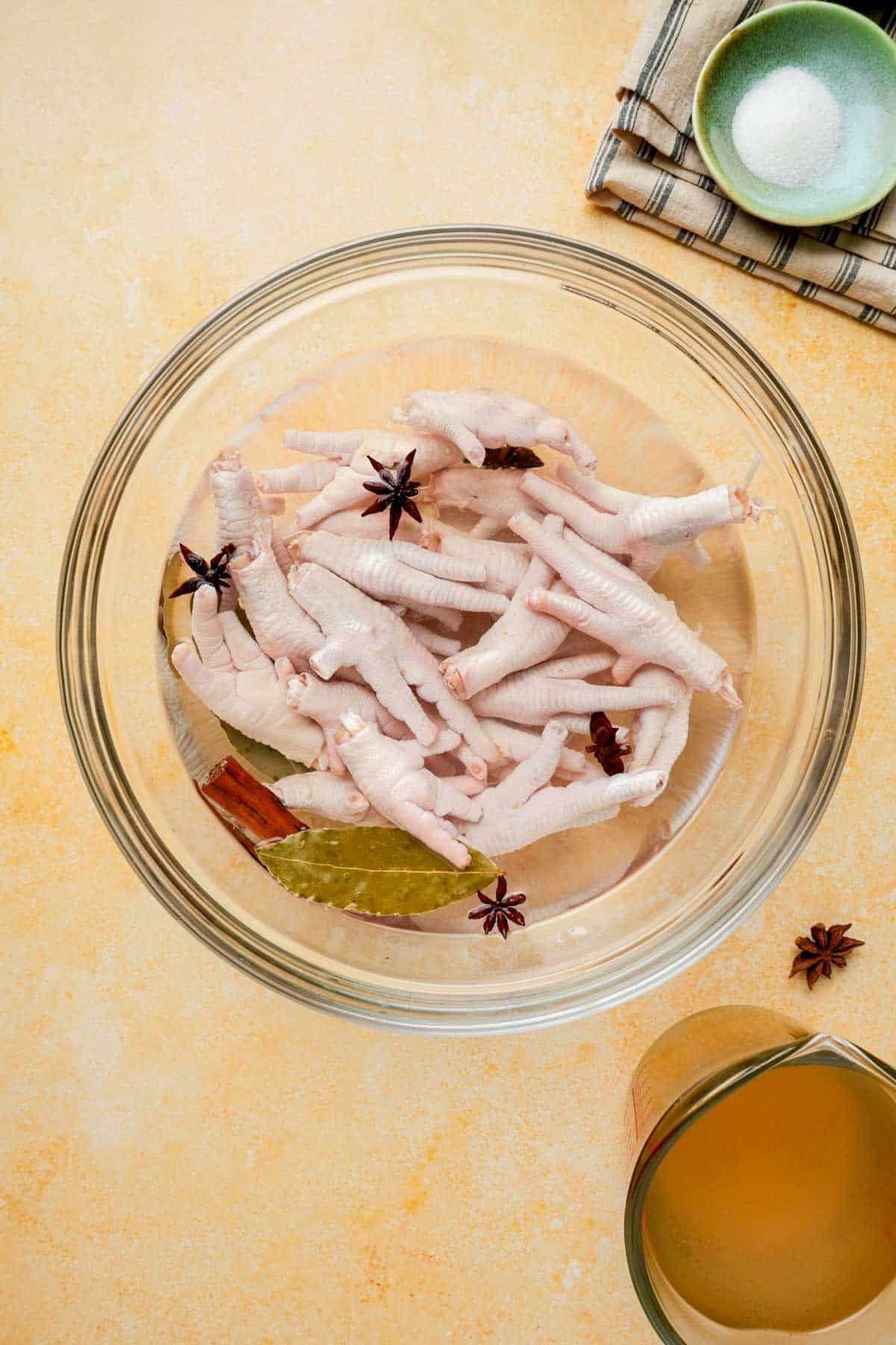 raw chicken feet in a bowl of water with spices