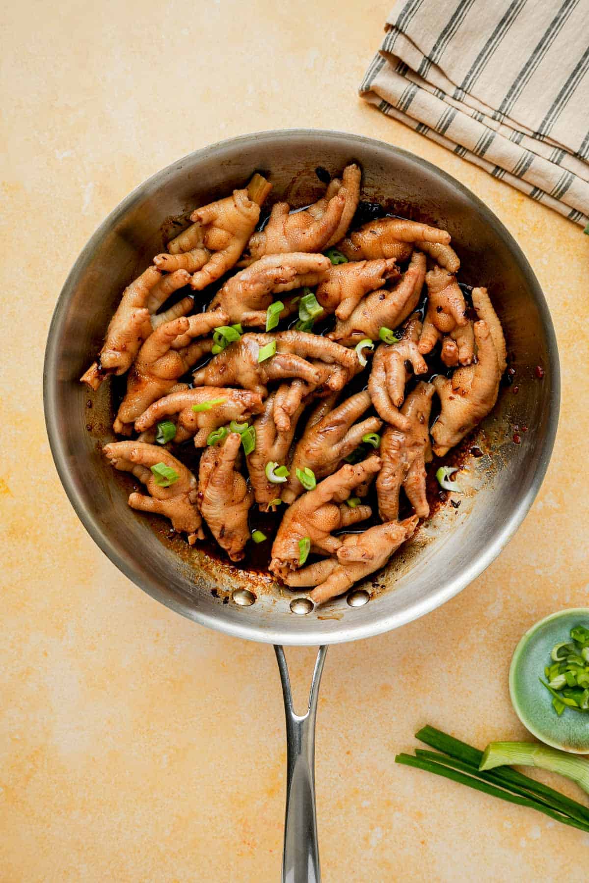 dim sum style chicken feet in a skillet with green onions