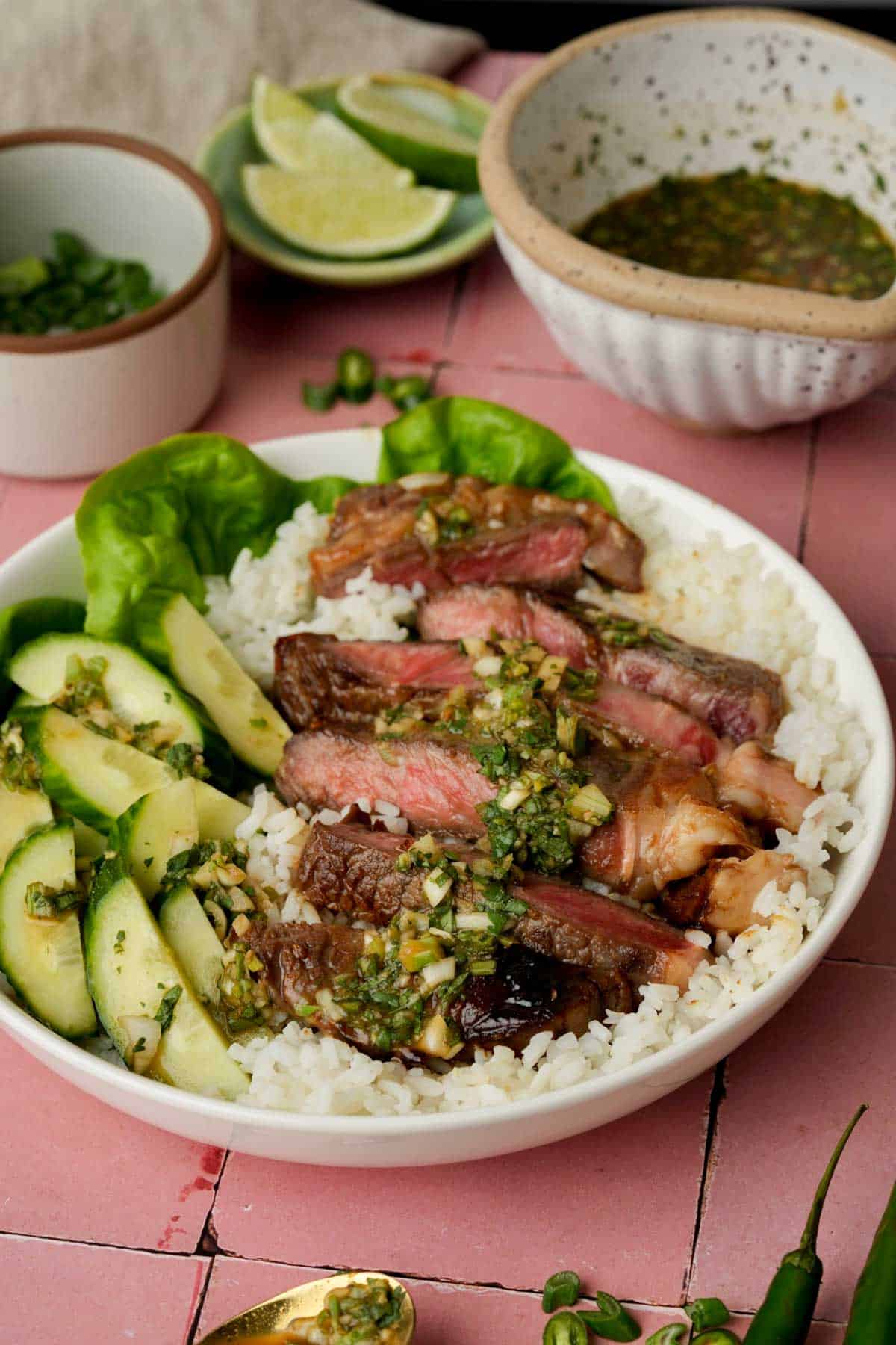 vegetables and beef on a plate with green sauce and rice