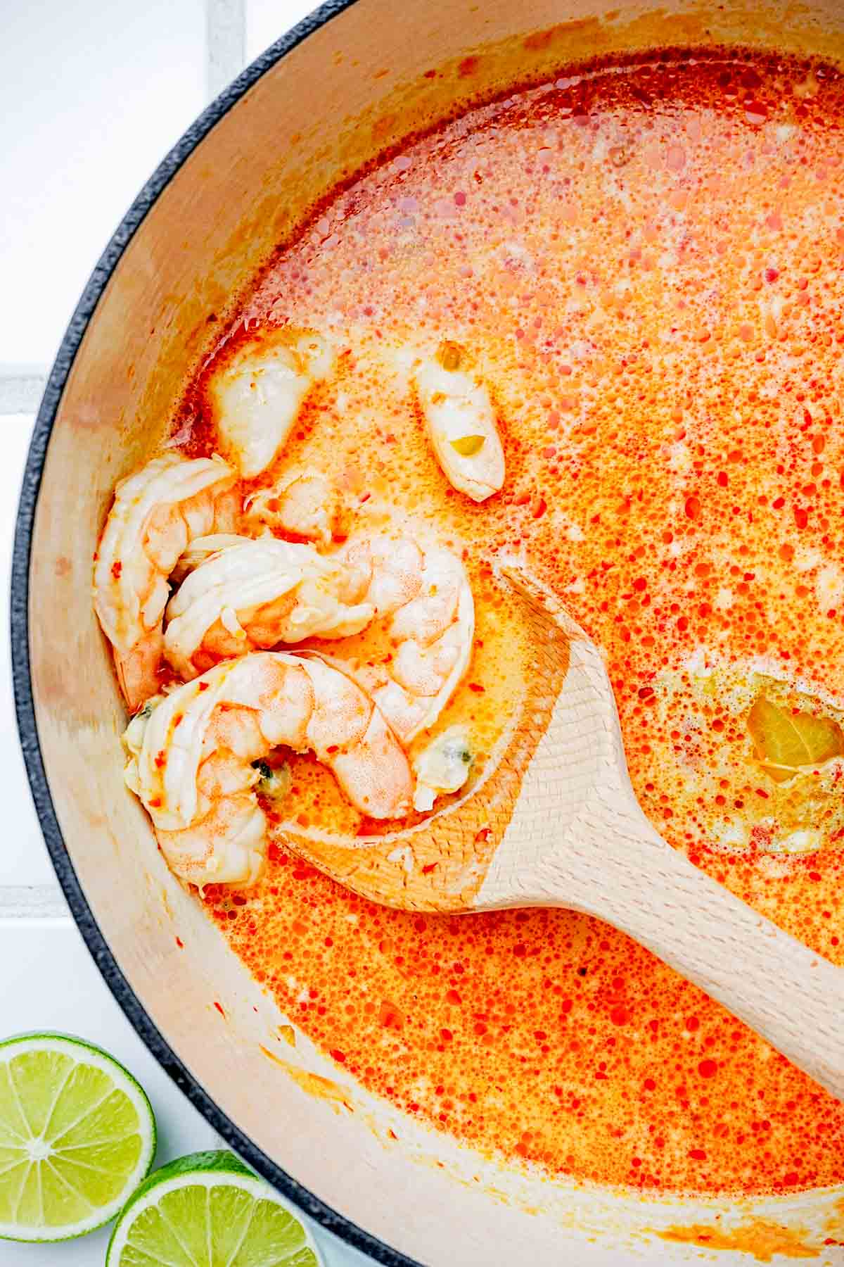 cooked shrimp in a pot of red liquid.