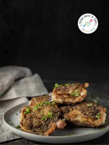 Crispy Chinese salt and pepper chicken thighs garnished with fresh green chilies on a white plate.