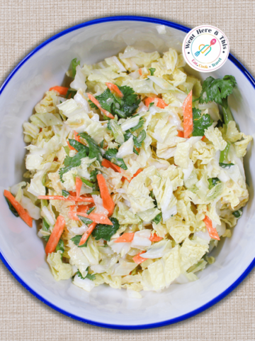 Creamy miso coleslaw with crunchy napa cabbage, carrots, and fresh cilantro in a blue-rimmed bowl.