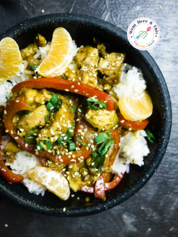 Glazed tangerine chicken stir fry with red peppers and sesame seeds over white rice.