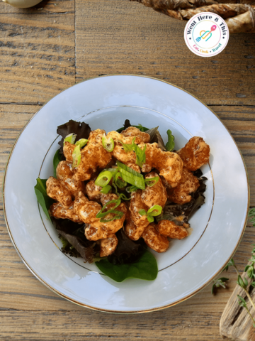 Close-up of crispy Bang Bang Chicken tossed in a creamy, spicy-sweet copycat bang bang sauce, garnished with fresh green scallions on a white plate by Went Here 8 This.