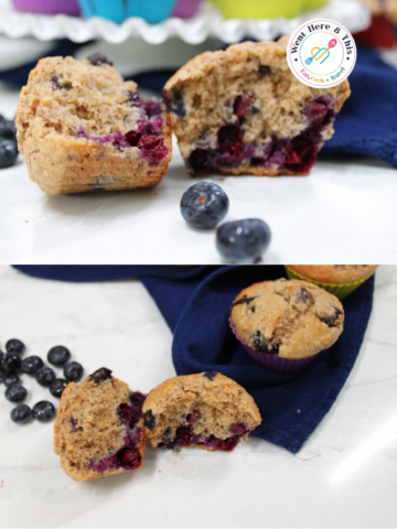 Two split-open moist oatmeal blueberry muffins with pecans showing a fluffy crumb texture and jammy blueberries, displayed alongside whole fresh blueberries and a blue cloth napkin on a white marble countertop.