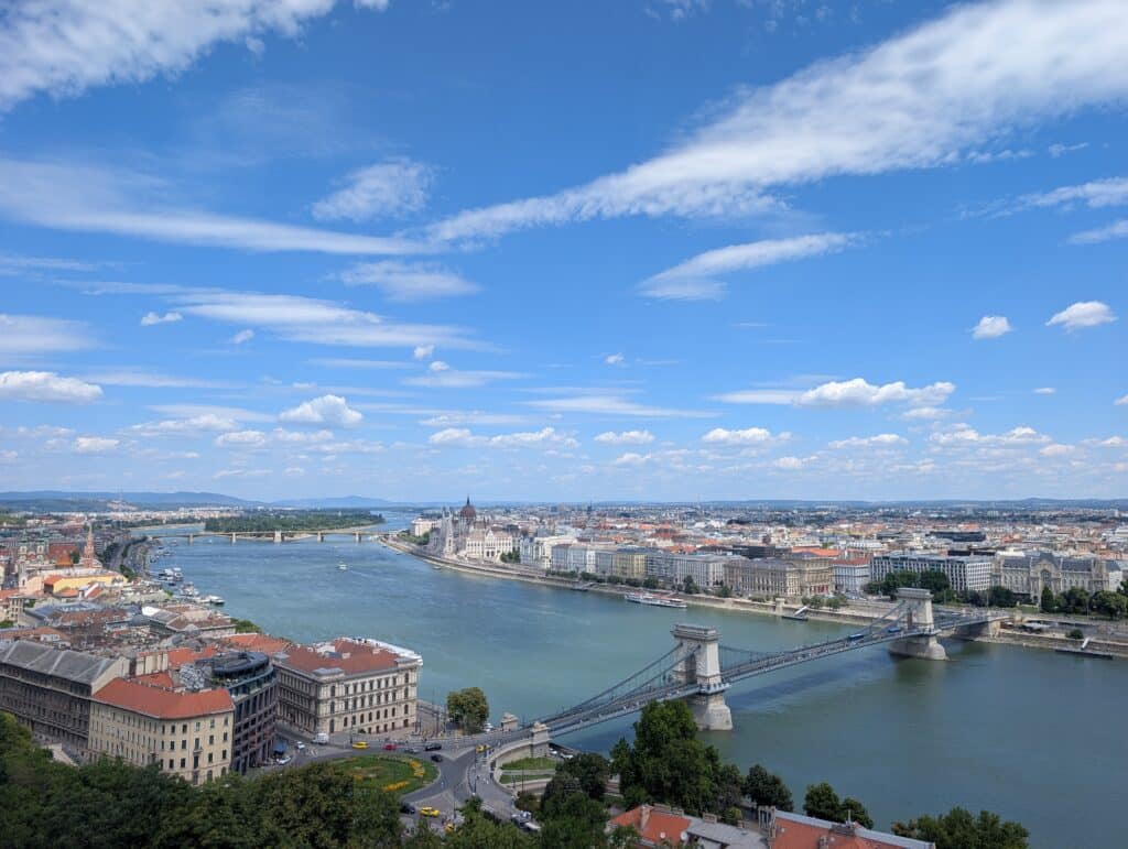 Scenic panoramic view of Budapest, Hungary, featuring the Danube River dividing the city into Buda and Pest from Buda Castle