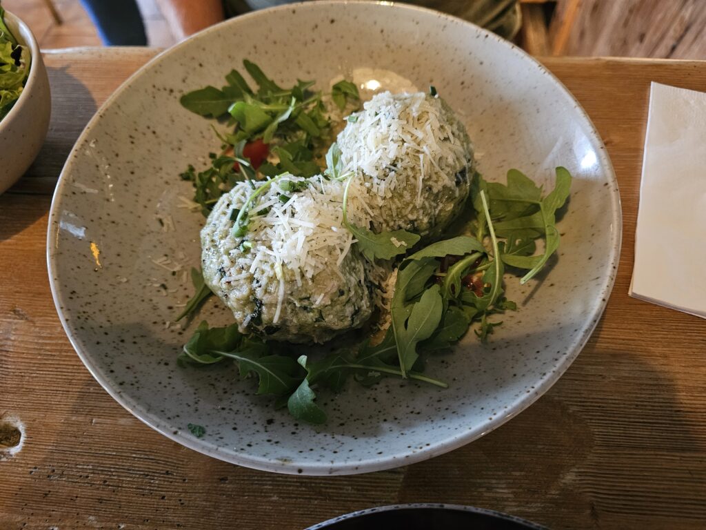 Austrian spinach dumplings, topped with melted butter and freshly grated Parmesan.