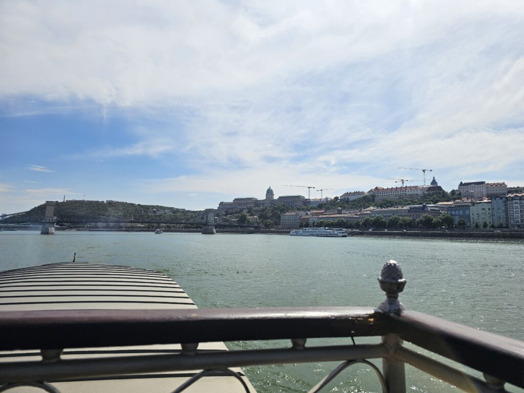 Danube River cruise, with a view of the historic Chain Bridge and Buda Castle visible in the background.