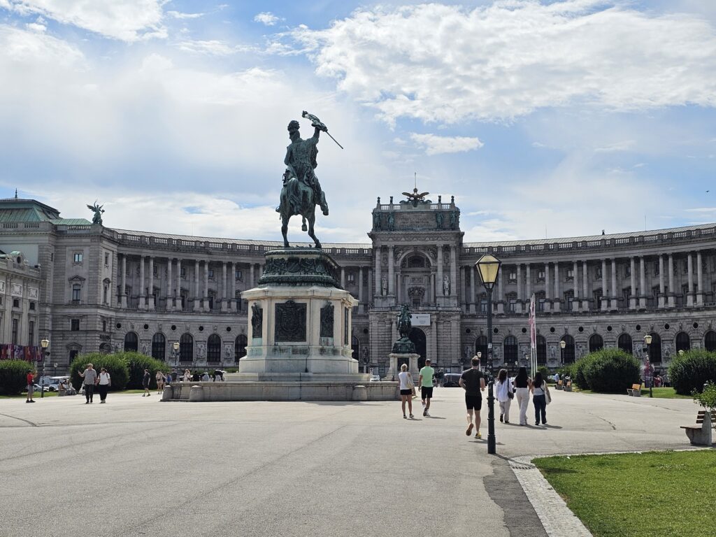 Heldenplatz (Heroes' Square) in Vienna featuring the grand Neue Burg wing of the Hofburg Palace and the iconic equestrian statue of Archduke Charles. The Neue Burg (New Burg) is the newest part of the Hofburg Palace complex, built between 1881 and 1913 in the neo-Baroque style.