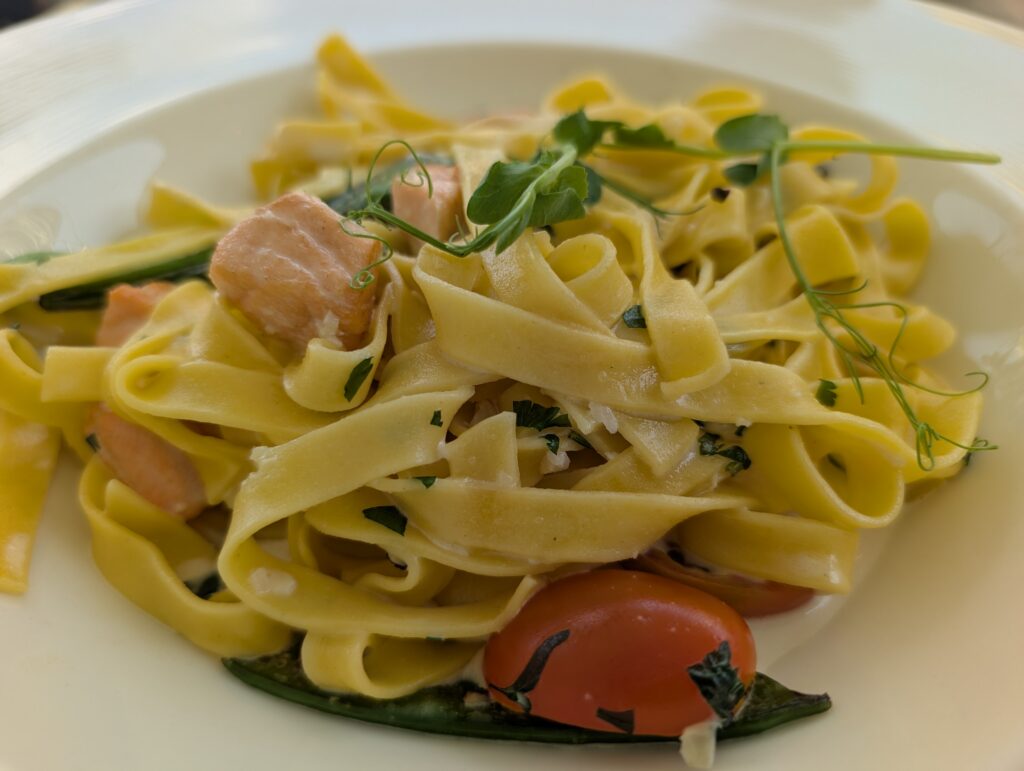 Wide ribbons of pasta tossed with tender pieces of salmon, green vegetables and cherry tomatoes, then finished with fresh herbs and delicate pea shoots.