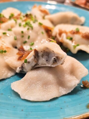 Mushroom pierogi a classic Eastern European dumpling filled with savory, earthy mushrooms with cheese and onions on top.
