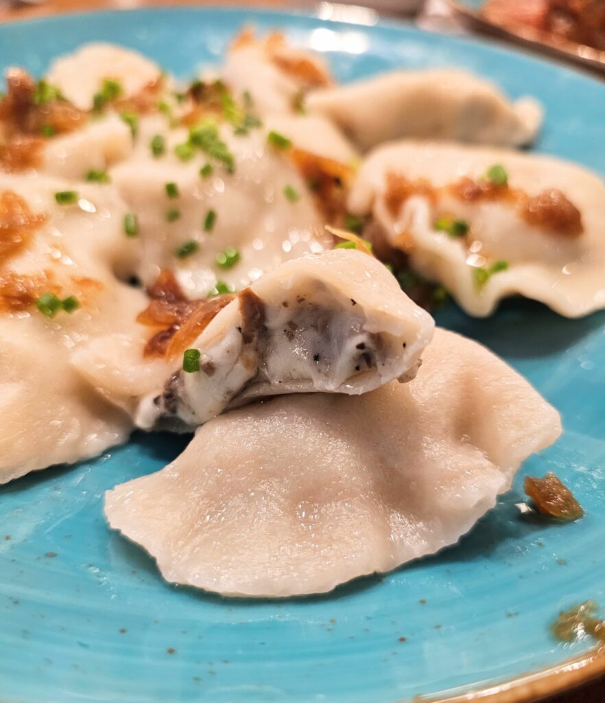 Mushroom pierogi a classic Eastern European dumpling filled with savory, earthy mushrooms with cheese and onions on top.