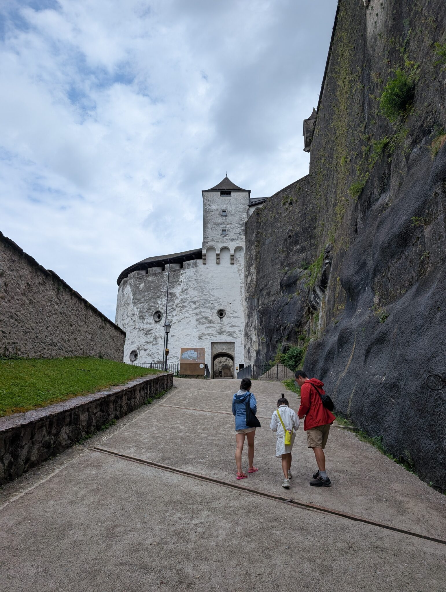 paved pathway toward the entrance gate of the historic Hohensalzburg Fortress. You can see how the fortress is build right into the rock.
