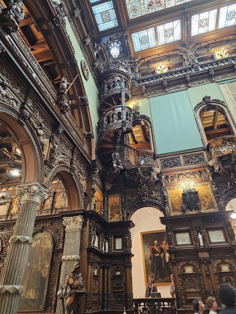 The stunning wooden interior in the Hall of Honor is so beautiful. The hall features three floors of intricate hand-carved dark walnut woodwork, elegant balconies, a delicate spiral staircase, and a retractable stained-glass ceiling.