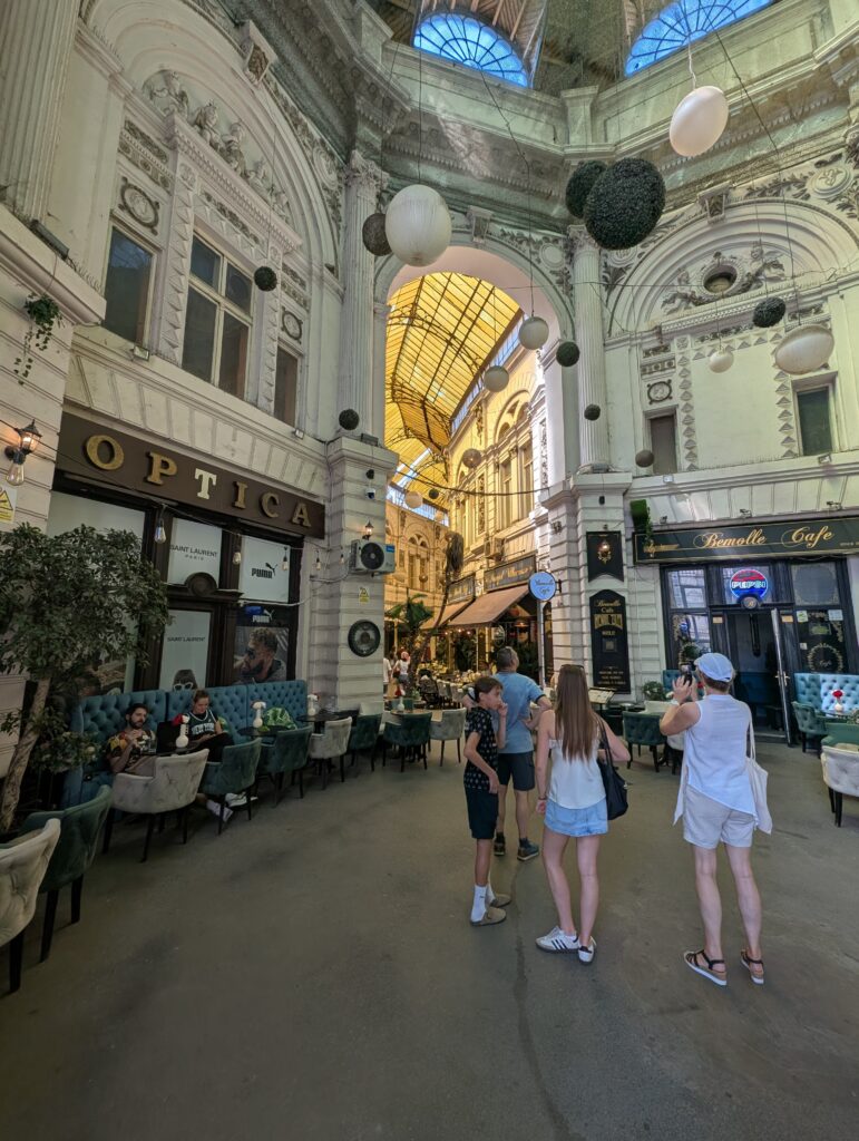 Tucked between the buzzing streets of Bucharest's Old Town, the Villacrosse–Macca Passage is one of the city’s most photogenic and atmospheric corners. With its yellow glass roof, Parisian vibe, and eclectic cafes.